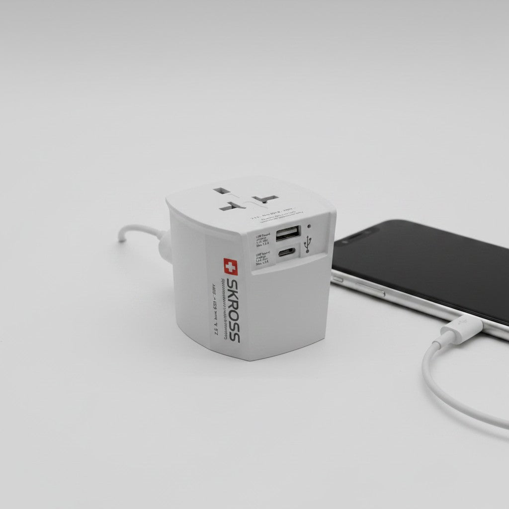 Adattatore da viaggio universale Mr Bob - Home & Tech Utility bianco con porte USB-A e USB-C collegato a smartphone